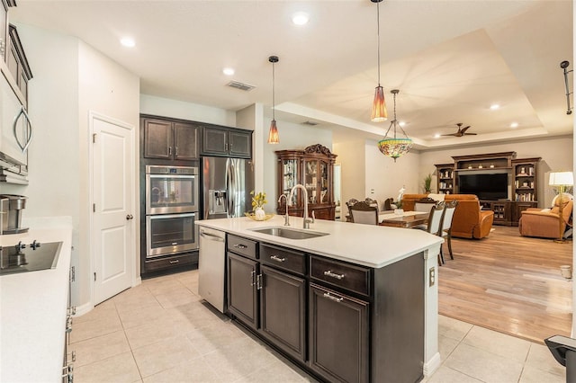 kitchen featuring light tile patterned floors, visible vents, a sink, appliances with stainless steel finishes, and a raised ceiling