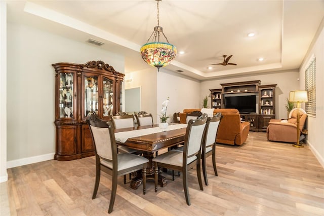 dining space featuring light wood finished floors, visible vents, baseboards, recessed lighting, and a raised ceiling