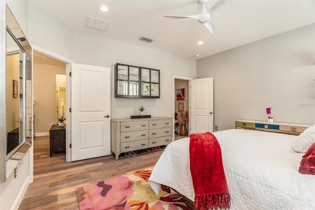 bedroom with a ceiling fan, recessed lighting, wood finished floors, and visible vents