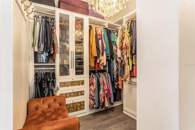 spacious closet with an inviting chandelier and wood finished floors