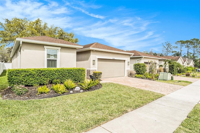 view of front of property featuring a front lawn, stucco siding, a garage, stone siding, and driveway