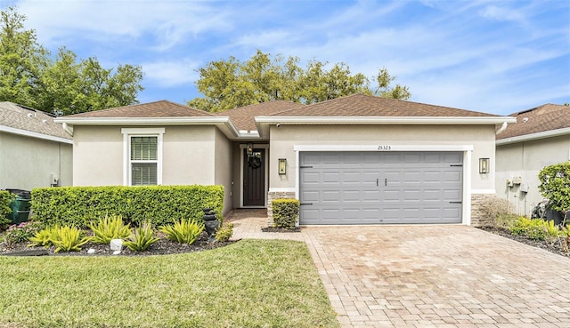 25325 Welsh Poppy Way, Land O Lakes, FL 34639 - single story home with stucco siding, decorative driveway, stone siding, a front yard, and an attached garage