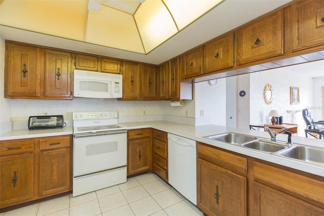 kitchen featuring light countertops, white appliances, light tile patterned flooring, and brown cabinets