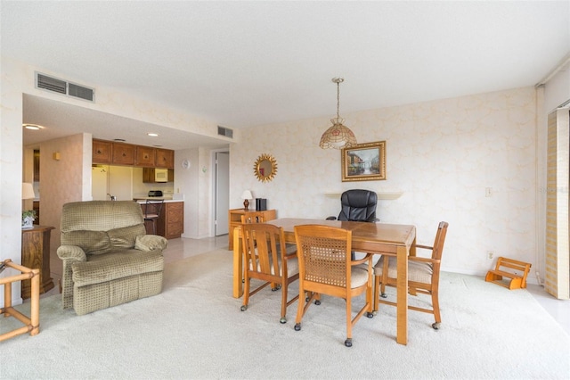 dining room featuring wallpapered walls, visible vents, and light colored carpet