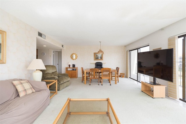 living area featuring visible vents and carpet flooring