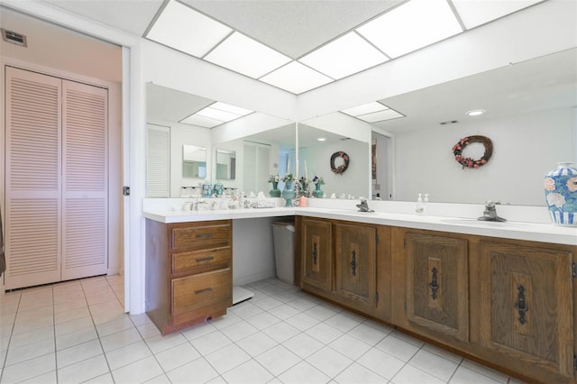 bathroom with a skylight, double vanity, a closet, visible vents, and a sink