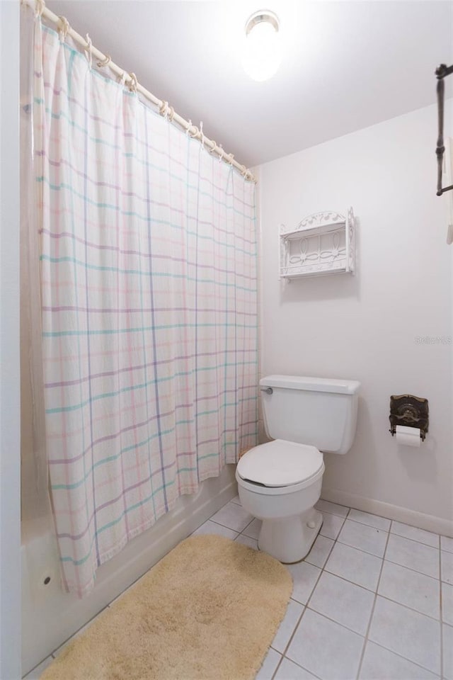 full bath featuring tile patterned flooring, baseboards, shower / tub combo with curtain, and toilet