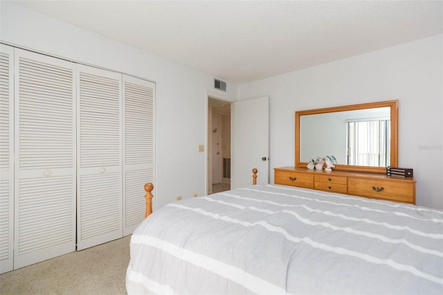 bedroom featuring a closet, light carpet, visible vents, and a textured ceiling