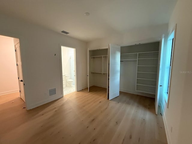 418 W Frances Ave Unit 2, Tampa, FL 33602 - unfurnished bedroom featuring light wood-style floors, two closets, baseboards, and ensuite bathroom