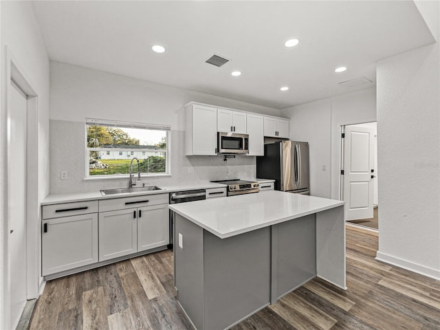 kitchen with wood finished floors, visible vents, appliances with stainless steel finishes, and a sink