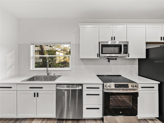 kitchen featuring light countertops, white cabinets, appliances with stainless steel finishes, and a sink