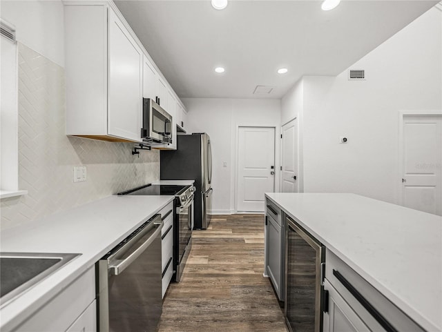 kitchen with visible vents, beverage cooler, dark wood finished floors, stainless steel appliances, and white cabinetry