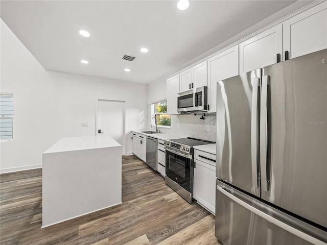 kitchen featuring a sink, backsplash, white cabinetry, appliances with stainless steel finishes, and dark wood-style flooring