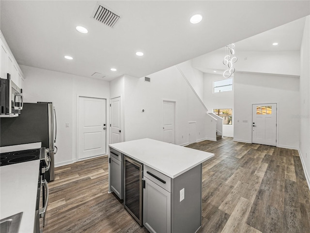 kitchen with visible vents, electric range, beverage cooler, gray cabinets, and stainless steel microwave