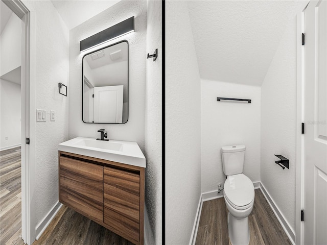 bathroom with vanity, toilet, wood finished floors, and a textured wall