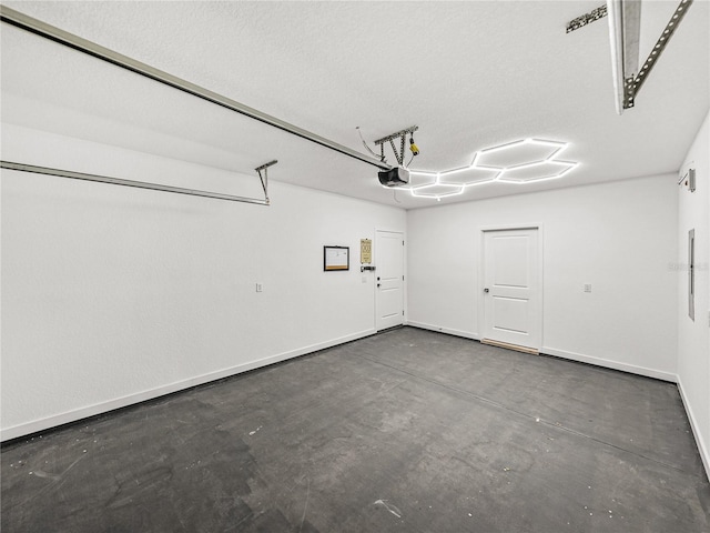 garage featuring a garage door opener and baseboards