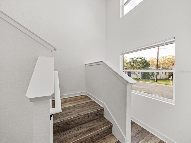 staircase with wood finished floors and baseboards