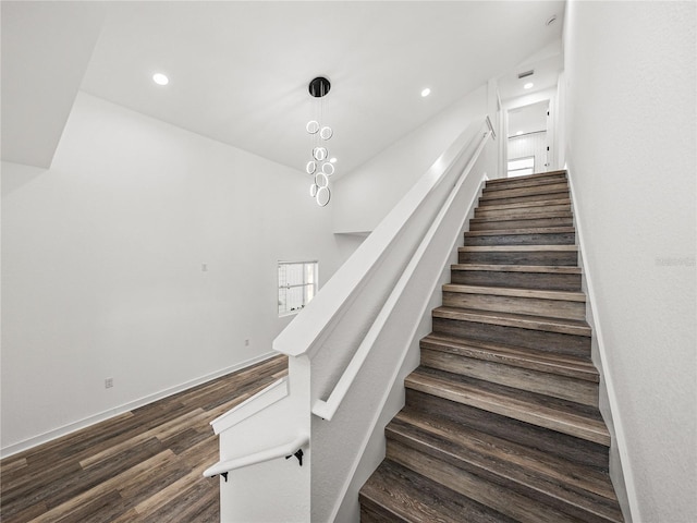 stairway featuring recessed lighting, wood finished floors, and baseboards