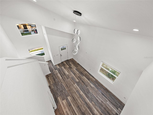 staircase with recessed lighting, high vaulted ceiling, and wood finished floors