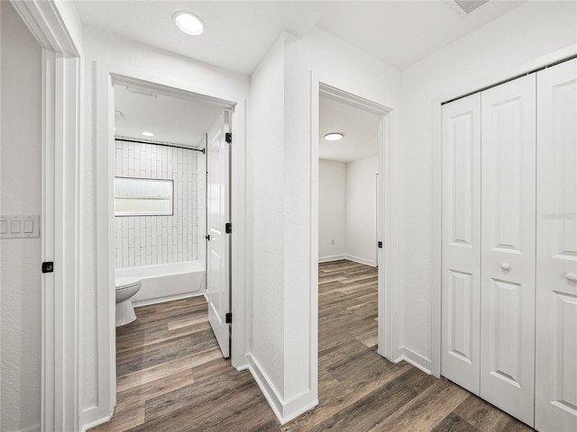 hallway with dark wood-type flooring, recessed lighting, and baseboards