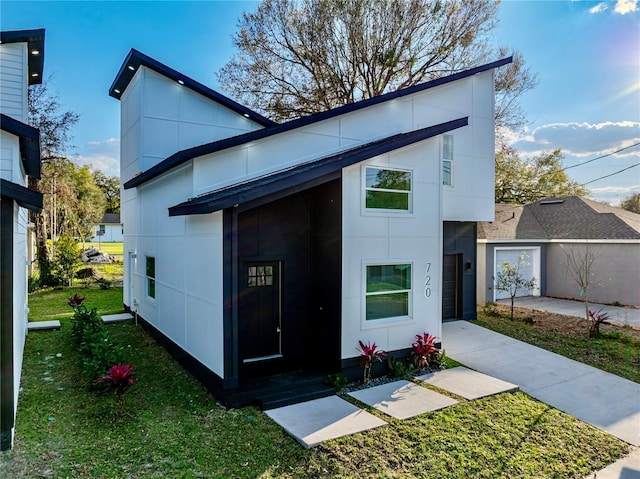 view of front facade featuring stucco siding and a front yard