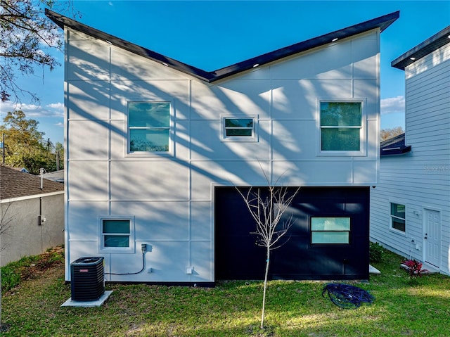 view of property exterior with central air condition unit and a lawn