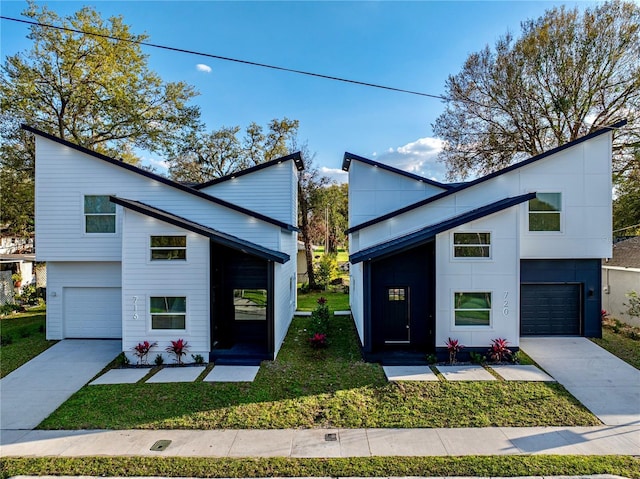 modern home with driveway, a front yard, and an attached garage