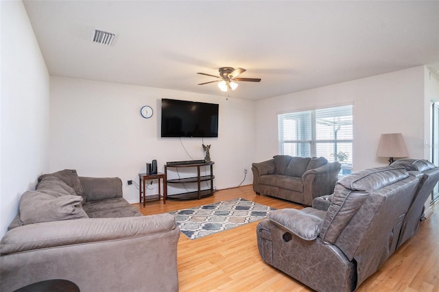 living area with light wood-style flooring, visible vents, and ceiling fan