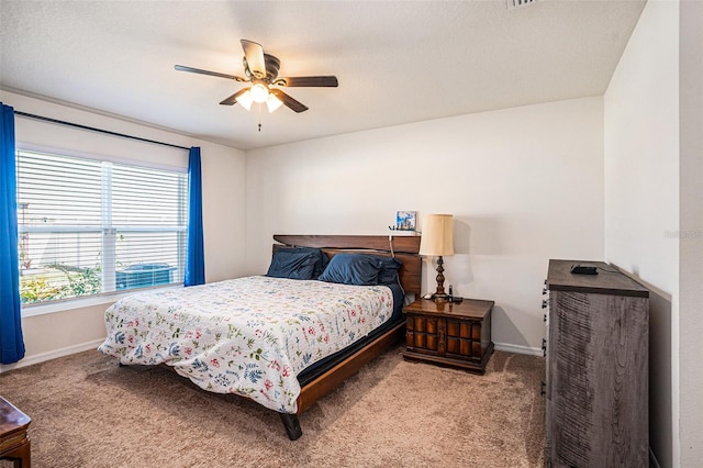 carpeted bedroom with ceiling fan and baseboards