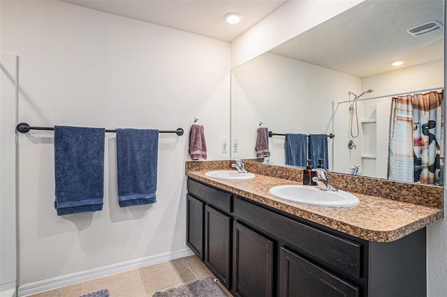 full bath with double vanity, baseboards, visible vents, and a sink