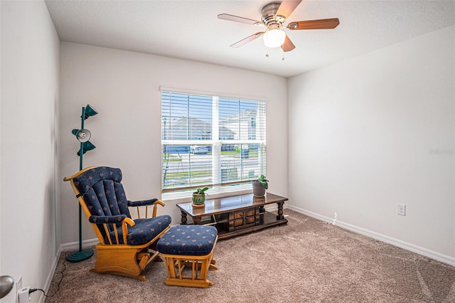 living area with ceiling fan, carpet floors, and baseboards