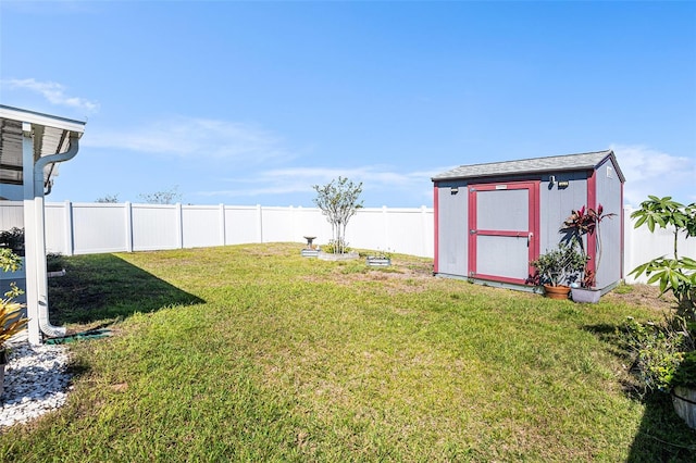 view of yard with a fenced backyard, a storage unit, and an outdoor structure