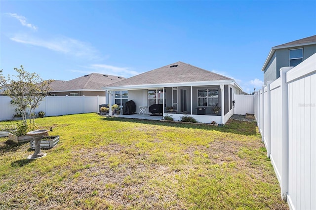 back of house with a shingled roof, a lawn, a sunroom, a patio area, and a fenced backyard