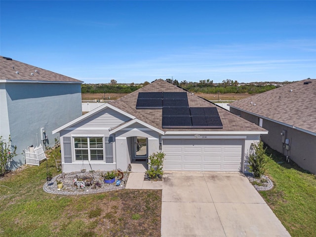 view of front of home featuring a garage, concrete driveway, a front yard, and solar panels