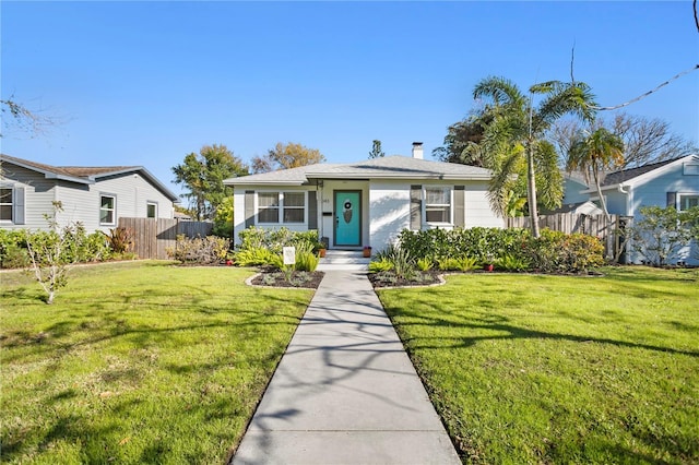 bungalow with a front lawn, a chimney, and fence