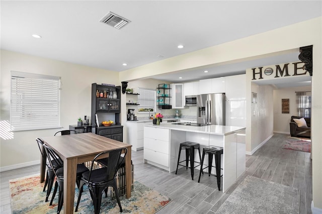 interior space featuring wood tiled floor, visible vents, baseboards, and recessed lighting