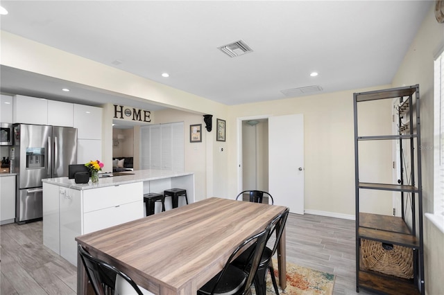 dining space featuring light wood-style flooring, visible vents, baseboards, and recessed lighting