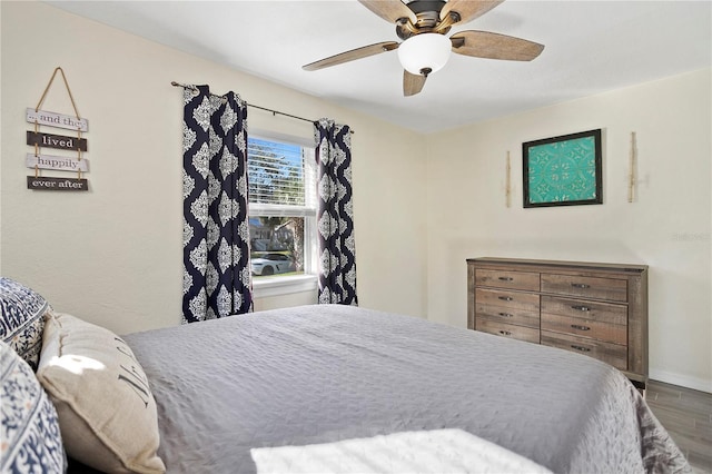 bedroom featuring ceiling fan, baseboards, and wood finished floors