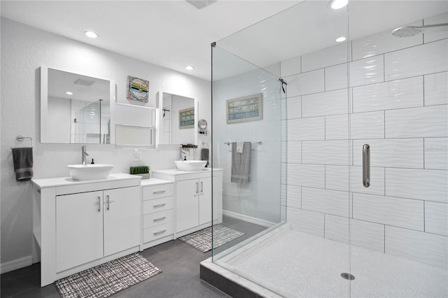 bathroom featuring a stall shower, two vanities, a sink, and recessed lighting