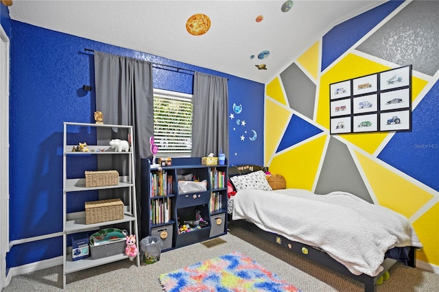 carpeted bedroom with a textured wall, a textured ceiling, and baseboards