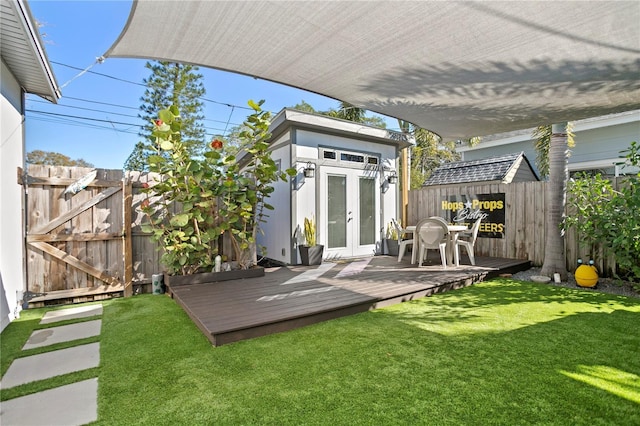 exterior space with an outbuilding, french doors, and fence