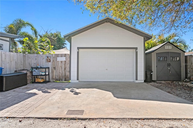 detached garage featuring a storage unit and fence