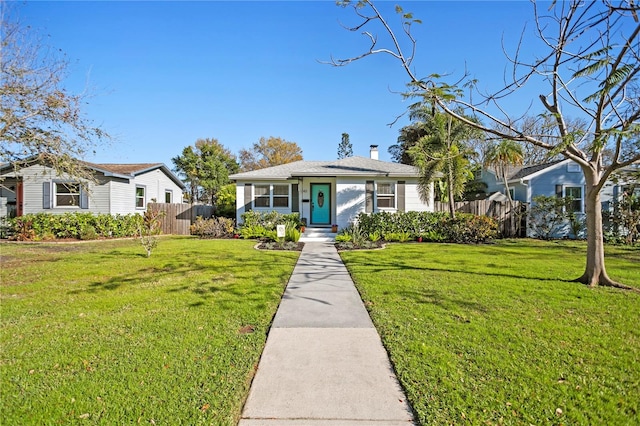 bungalow-style home with a chimney, fence, and a front yard