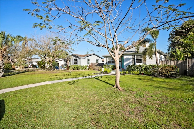 view of front of home with a front yard and fence