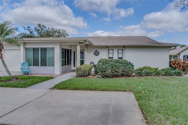 single story home featuring a front lawn and stucco siding