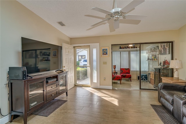 foyer with baseboards, visible vents, ceiling fan, a textured ceiling, and light wood-type flooring