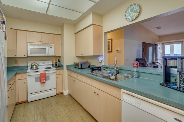 kitchen featuring light wood-type flooring, white appliances, visible vents, and a sink