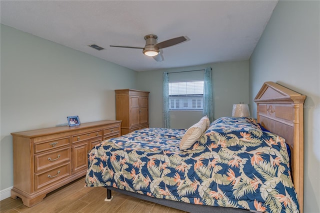 bedroom with light wood-type flooring, visible vents, and a ceiling fan