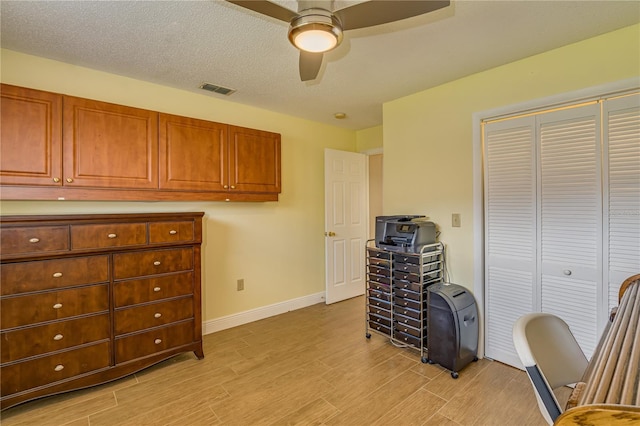 office area featuring ceiling fan, baseboards, visible vents, and light wood-style floors