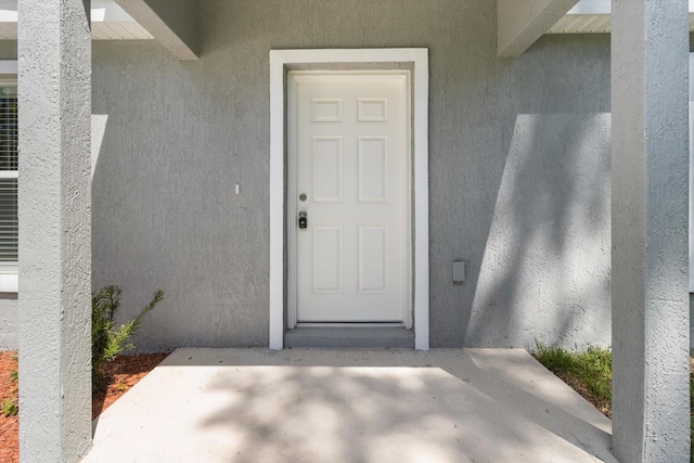 doorway to property featuring a patio and stucco siding